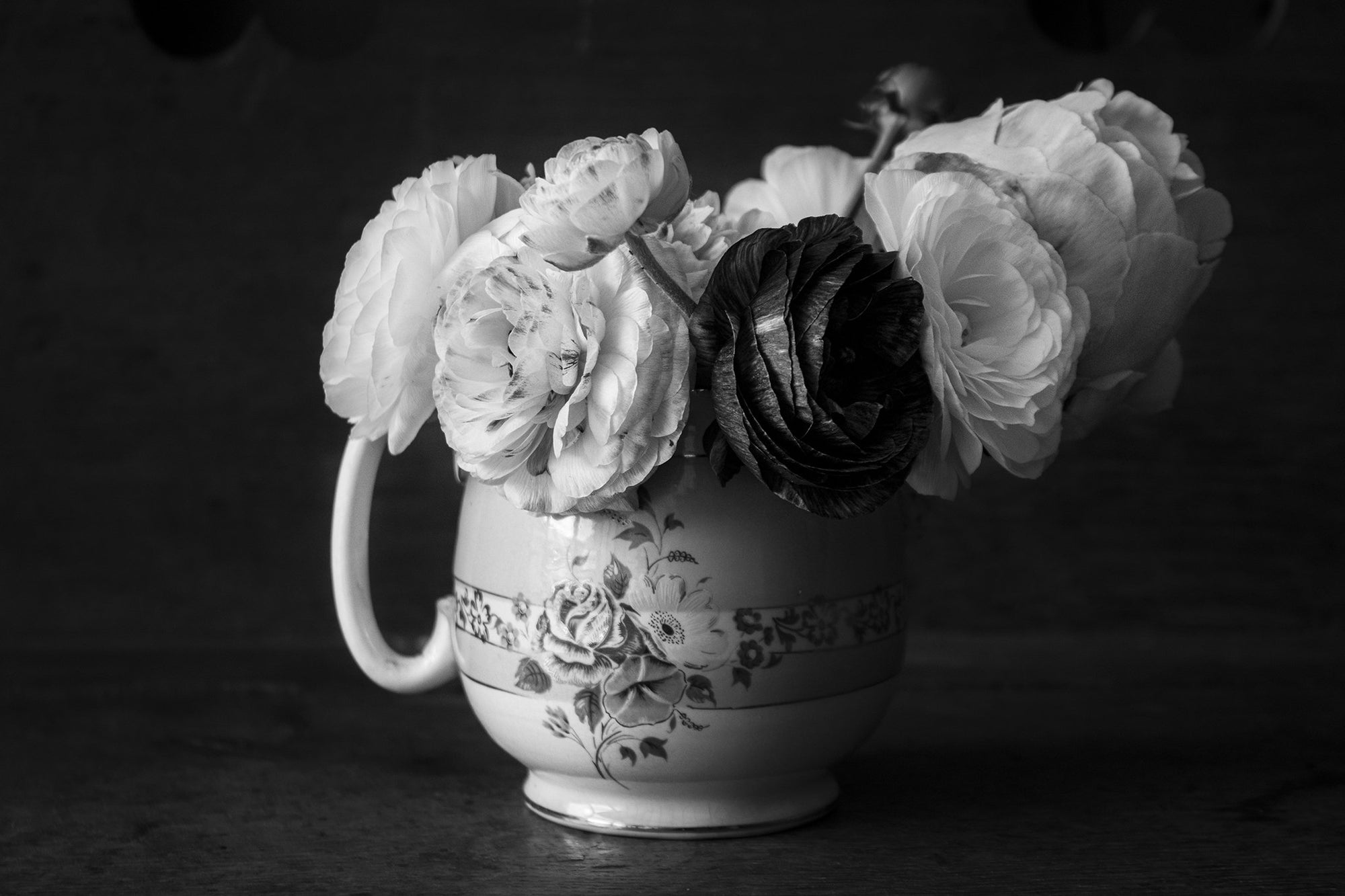 Peonies and Ranunculus flowers in a vintage vase jug in black and white